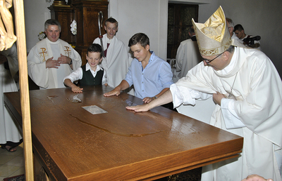 Bischof Wilhelm Krautwaschl bittet die Kinder zur Weihe des neuen Altars nach vorne.