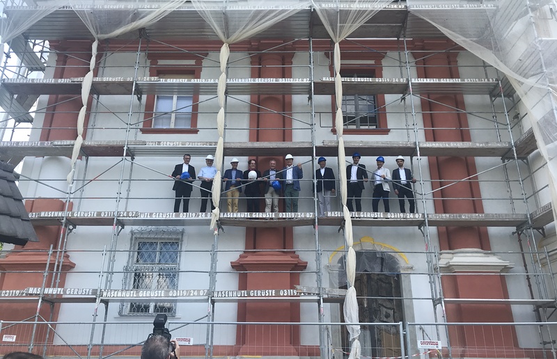 Sponsoren und Vertreter der Kirche beim Besichtigen der neuen Fassade. Der zukünftige Farbton ist jener links außen.