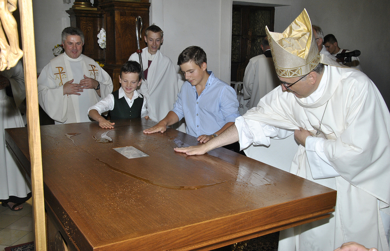 Bischof Wilhelm Krautwaschl bittet die Kinder zur Weihe des neuen Altars nach vorne.