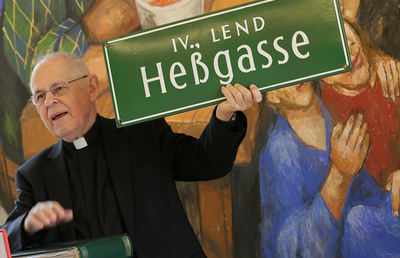 Pfarrer Pucher mit dem Straßenschild der Gasse, in der einst alles begann: der Grazer Heßgasse (heute namenlos).