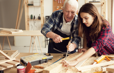 Grandpa with granddaughter enjoy  at grandpa's carpentry workshop