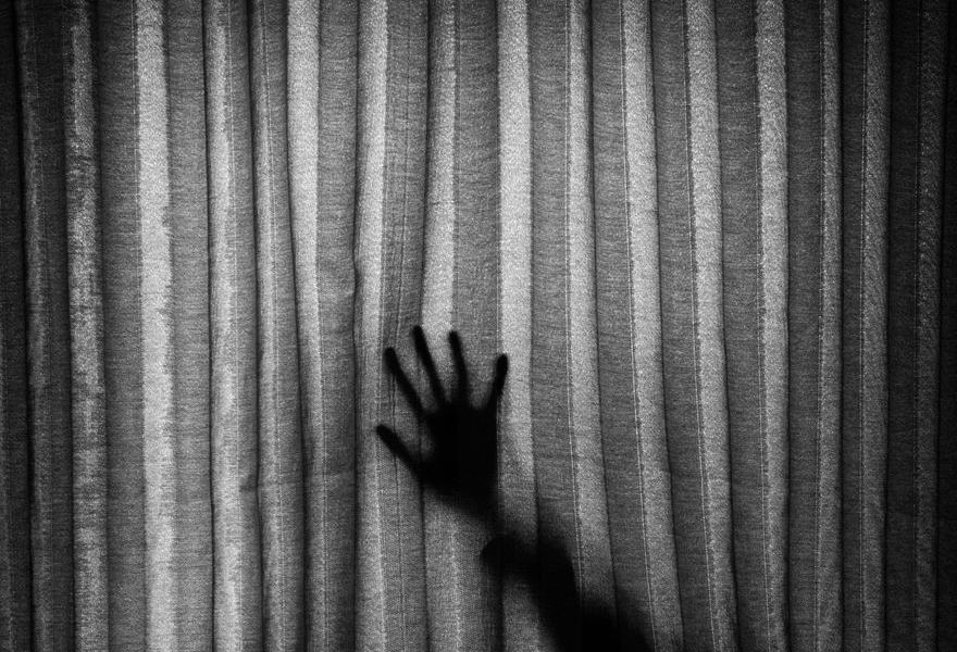 Hand hinter Vorhang, schwarz-weiß